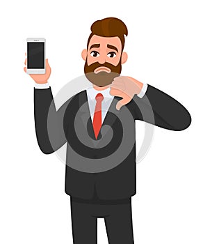 Unhappy businessman holding/showing brand new smartphone, mobile, cell phone in hand and gesturing thumbs down sign. Human emotion