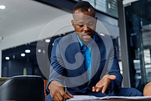 Unhappy businessman reading reports while sitting in office