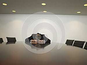 Unhappy Businessman Sitting In Conference Room