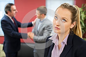 Unhappy Businesswoman With Male Colleague Being Congratulated