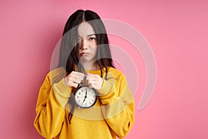 unhappy caucasian female with alarm clock in hands