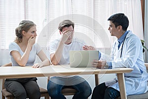 Unhappy caucasian young couple worried result of health illness examining after talking and discussion with expertise.Women shock