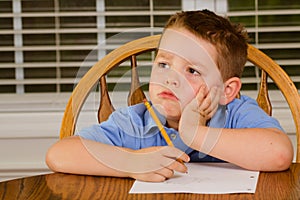 Unhappy child doing his homework