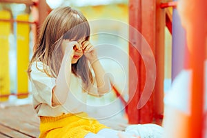 Upset Little Girl Playing with her Friend Rubbing her Eyes