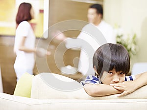 Unhappy child and quarreling parents photo