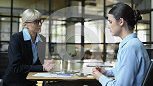 Unhappy company director scolding female employee checking sales result tablet