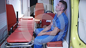 Unhappy corpsman sit in ambulance car at night.