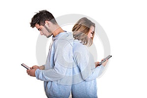 Unhappy couple backwards with their mobile phones typing isolated