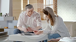 Unhappy couple calculating income and expenses of family budget, unemployment