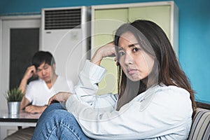 Unhappy couple not talking after an argument at home. depressed woman sitting on the sofa and sad man sitting on the table.