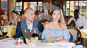 Unhappy couple quarreling during dinner at restaurant