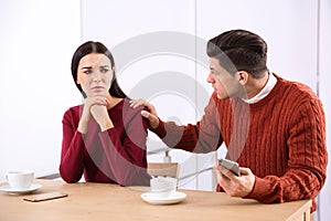 Unhappy couple with relationship problems at table