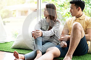 Unhappy Couple sitting beside each other on the floor and avoid talking or quarrel, Cause of relationship problems and having