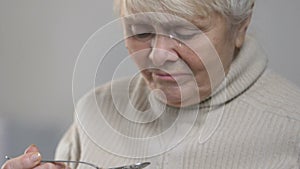 Unhappy crying woman eating tasty porridge in nursing home, feeling homesick