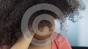 Unhappy curly African girl sitting alone at table, social service for children