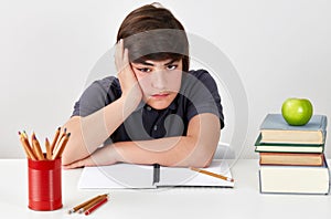 Unhappy and depressed student boy is feeling confused  while doing his homework