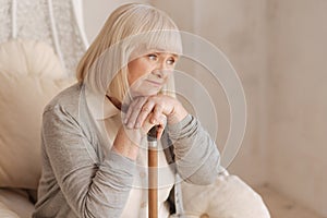 Unhappy depressed woman leaning on her walking stick