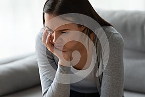 Unhappy depressed young woman thinking about problem alone close up
