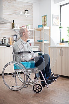 Unhappy disabled senior man sitting in wheelchair