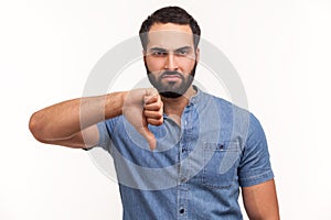 Unhappy dissatisfied man with beard showing thumbs down dislike gesture, symbol of disagree, giving feedback