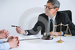 Unhappy divorce couple having conflict, husband and wife during divorce process with senior male lawyer or counselor and couple