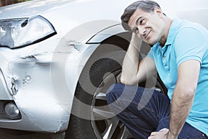 Unhappy Driver Inspecting Damage After Car Accident