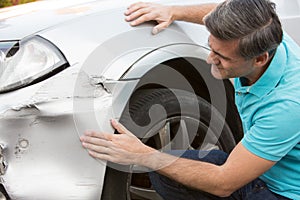 Unhappy Driver Inspecting Damage After Car Accident