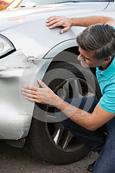 Unhappy Driver Inspecting Damage After Car Accident