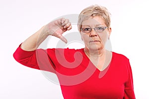Unhappy elderly woman showing thumbs down, negative emotions in old age