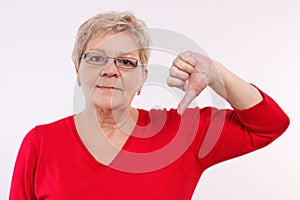 Unhappy elderly woman showing thumbs down, negative emotions in old age