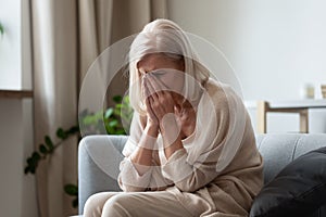 Unhappy old woman crying at home feeling lonely