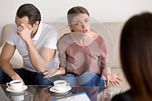 Unhappy emotional wife talking to psychologist about problems in