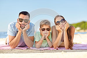 Unhappy family lying on summer beach