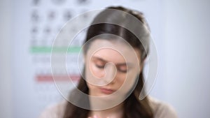 Unhappy female suffering migraine and taking off glasses, wrong lens diopter