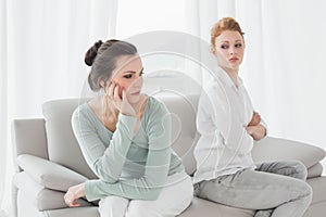 Unhappy friends not talking after argument on the couch photo