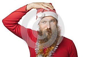 Unhappy funny santa claus with real beard and red hat and shirt looking at camera with sadness. isolated on white