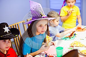 Unhappy girl eating pizza at party. Birthday celebration with pizza photo