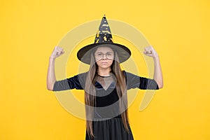 Unhappy girl ready to celebrate. costume party fun. happy halloween. powerful child in witch hat and glasses. kid goes