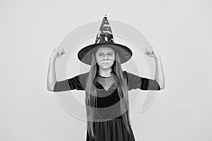 unhappy girl ready to celebrate. costume party fun. happy halloween. powerful child in witch hat and glasses. kid goes