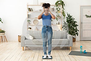 Unhappy Girl Standing On Scales Having Excess Weight Posing Indoors