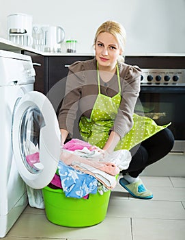 Unhappy girl using washing machine