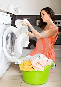 Unhappy girl using washing machine at home