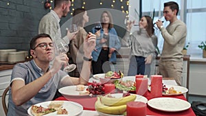 Unhappy guy feeling lonely on holiday in front of decorated house. Concept of depression.