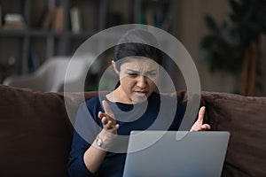 Unhappy Indian woman have problems working on laptop