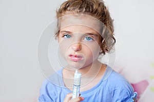 Unhappy kid girl with syringe medicine dose