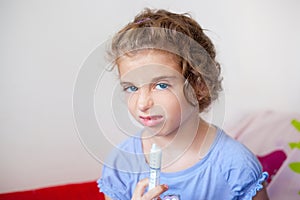 Unhappy kid girl with syringe medicine dose