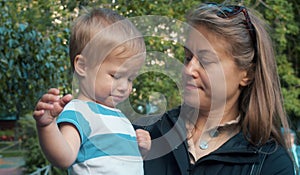 Unhappy kid sitting on the mother`s hands