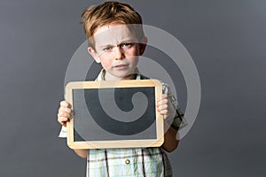 Unhappy little child showing empty writing slate to express reflection