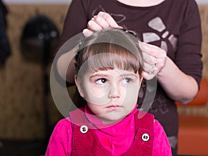 Unhappy little girl at barbershop