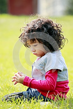 Unhappy little girl on the grass